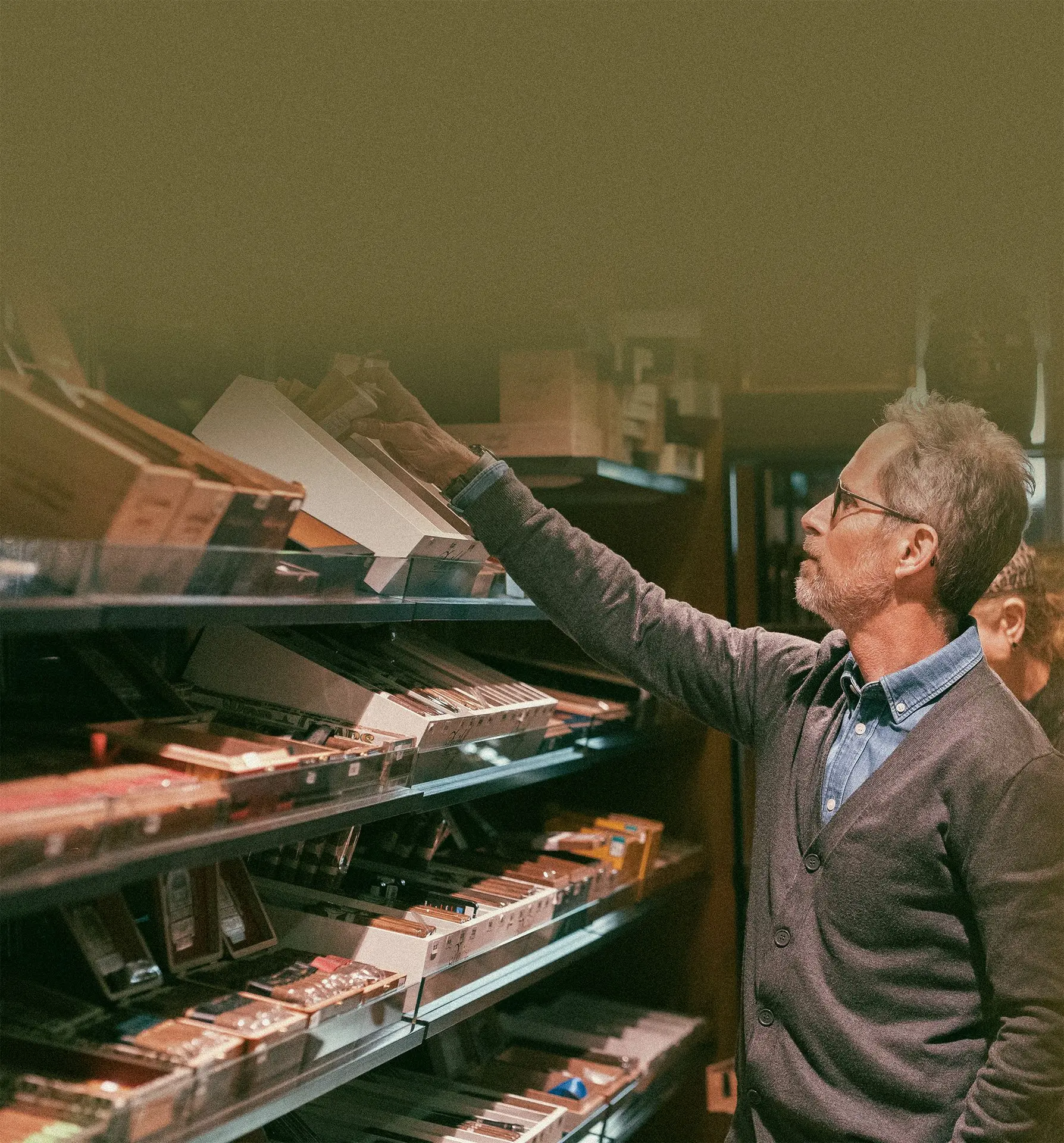 Propriétaire d’Histoires de Cigares rangeant des cigares haut de gamme en boutique
